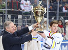 Председатель Федерации хоккея Беларуси Семен Шапиро вручает кубок победителям турнира "Золотая шайба" – команде "Медведь"
