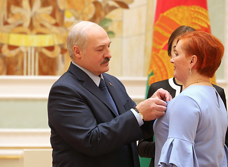Alexander Lukashenko presents the Order of Mother to creative director of the folk song band Vabichanskiye Uzory Yelena Kalakustova