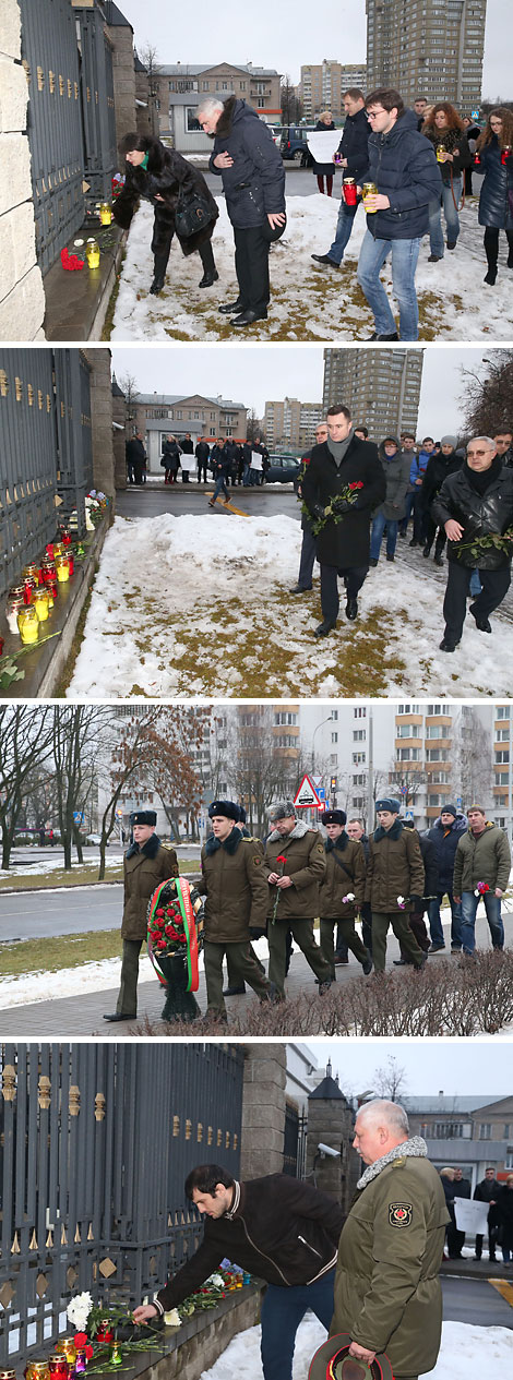 Минчане и представители общественных организаций несут цветы и лампады к посольству России в Беларуси