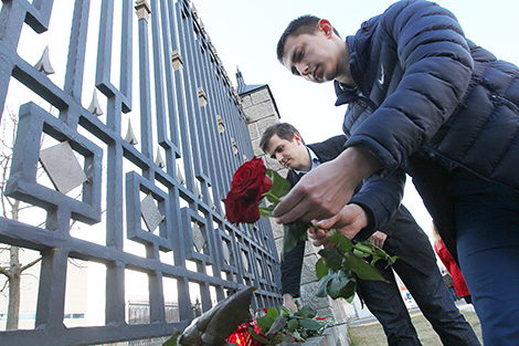 Представители общественных организаций несут цветы и лампады к посольству России в Беларуси
