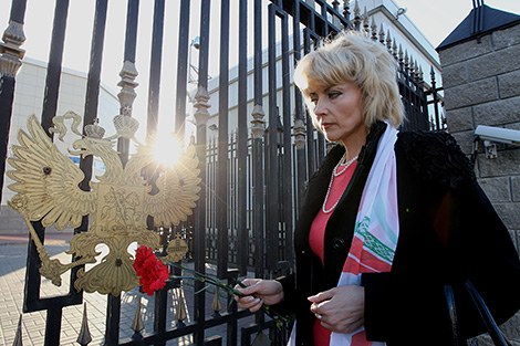 Представители общественных организаций несут цветы и лампады к посольству России в Беларуси