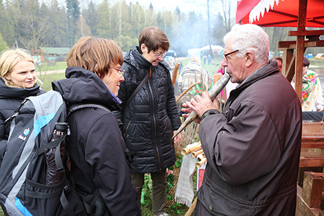 Марьян Скраблевич демонстрирует иностранным туристам белорусские музыкальные инструменты