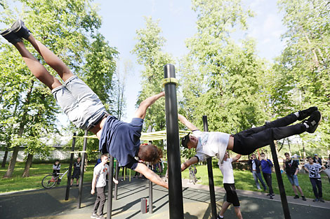 Упражнения юных атлетов на ворк-аут площадке в городском парке Вилейки