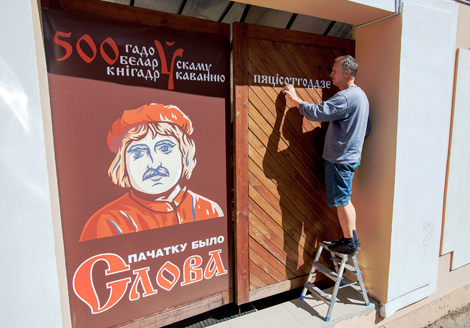 Director of the Paper advertising agency Albert Markov decorates the gate in the run-up to the Day of Belarusian Written Language 