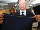 Председатель концерна "Беллегпром" Николай Ефимчик демонстрирует знак качества, определяющий лучших производителей шерстяных тканей