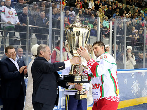 Старшыня Федэрацыі хакея Беларусі Сямён Шапіра ўручае кубак пераможцам Каляднага турніру