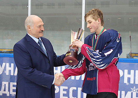 Александр Лукашенко вручает кубок команде 