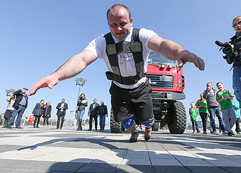 Belarus' strongman Alexander Kurak competes in MAZ truck pull