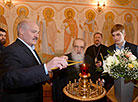 Alexander Lukashenko, Metropolitan Filaret and Nikolai Lukashenko light Easter candles