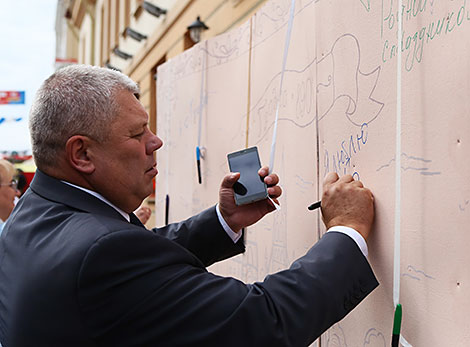 Grodno Mayor Mechislav Goi is writing a message for the city
