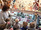 Воспитательница  Зароновского детского сада Елена Драйлих знакомит ребятишек с новогодними игрушками