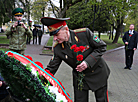 Belarusian border guards lay flowers at a monument near a mass grave in Minsk