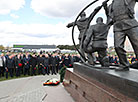 A commemorative rally near a memorial sign in honor of Chernobyl cleanup workers in Khoiniki