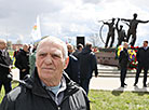 A commemorative rally near a memorial sign in honor of Chernobyl cleanup workers in Khoiniki