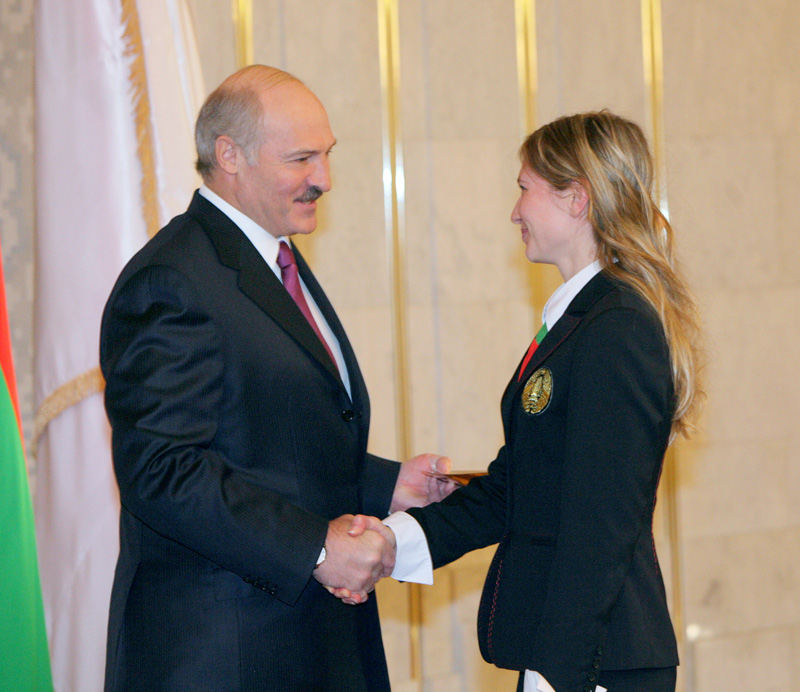 Президент Беларуси Александр Лукашенко вручает Дарье Домрачевой знак МОК