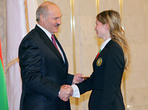 Президент Беларуси Александр Лукашенко вручает Дарье Домрачевой знак МОК